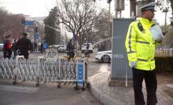 Chinese policemen stand guard at a road barricade in