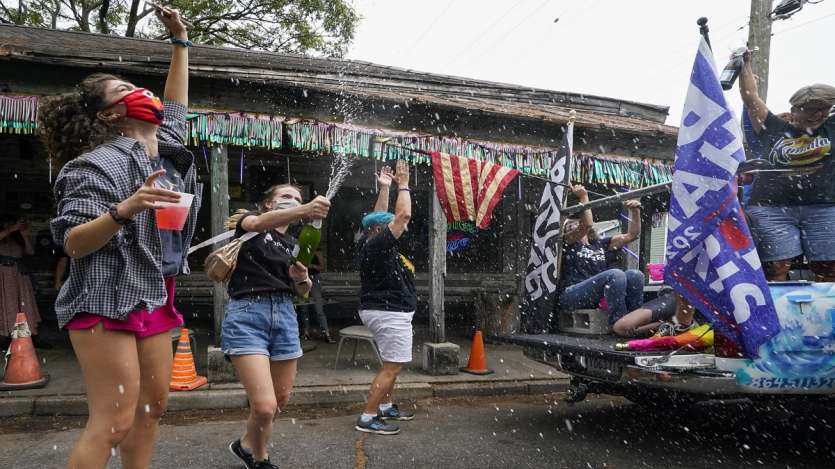 People celebrate outside Vaughn's Lounge in the Bywater section of New Orleans, after news outlets called the Presidential election in favor of President-elect Joe Biden and his running mate, Vice President-elect Kamala Harris.